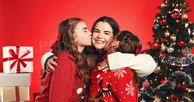 Buy stock photo Christmas, portrait and mom with children, kiss or excited for December holiday, bonding and studio. Happy, woman and embrace with girls, love and kids with affection on Xmas season or red background