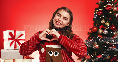 Buy stock photo Portrait, Christmas and girl with heart, studio or smile for December celebration or festive holiday. Red background, love shape and teenager with Xmas sweater, presents or tree with ornaments in USA