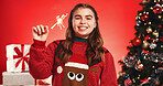 Portrait, Christmas and girl with sparkler, studio and excited for celebration and December holiday. Red background, teenager and happy with Xmas sweater, presents and tree with ornaments in USA