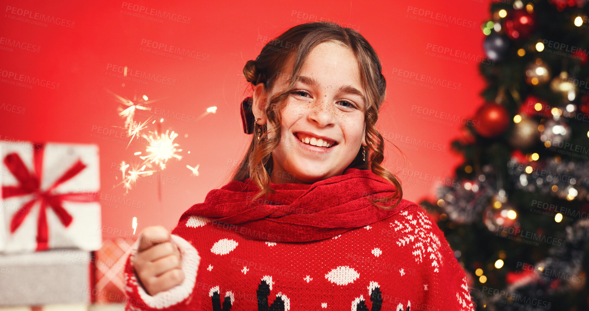 Buy stock photo Portrait, Christmas and child with sparkler, studio and excited for celebration or December holiday. Red background, festive season and girl with Xmas sweater, presents and tree with ornaments in USA