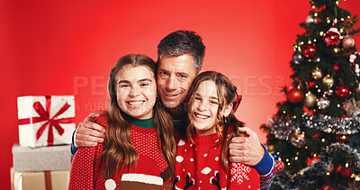 Buy stock photo Christmas, hug and portrait of father with daughter kids in studio for celebration or tradition. Family, presents or tree with girl children and man parent isolated on red background for holidays