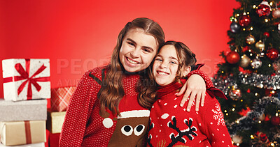 Buy stock photo Christmas, portrait and girls hug with siblings for love, holiday celebration and festive season. Smile, children and embrace on xmas with sisters, family and vacation on red studio background