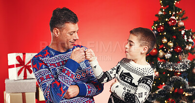 Buy stock photo Christmas, fist bump and father with child in studio for celebration, support and holiday season. Happy man, son and festive event for xmas vacation, bonding and December together on red background
