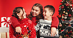 Siblings, children and happy for Christmas, studio or bonding on December holiday, hug and laughing. Family, kids and teenager with Xmas sweater, embrace and love on festive season and red background