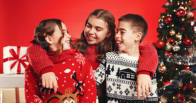 Buy stock photo Siblings, children and happy for Christmas, studio or bonding on December holiday, hug and laughing. Family, kids and teenager with Xmas sweater, embrace and love on festive season and red background