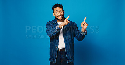Buy stock photo Portrait, pointing up and man in studio, smile and announcement with offer on blue background. Model, space and happy person with hand gesture, opinion and opportunity with decision or choice