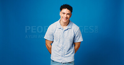 Buy stock photo Portrait, smile and man in studio, fashion and confident personality on blue background. Mockup space, pride and person with happiness, gen z and friendly with stylish clothes, calm and streetwear