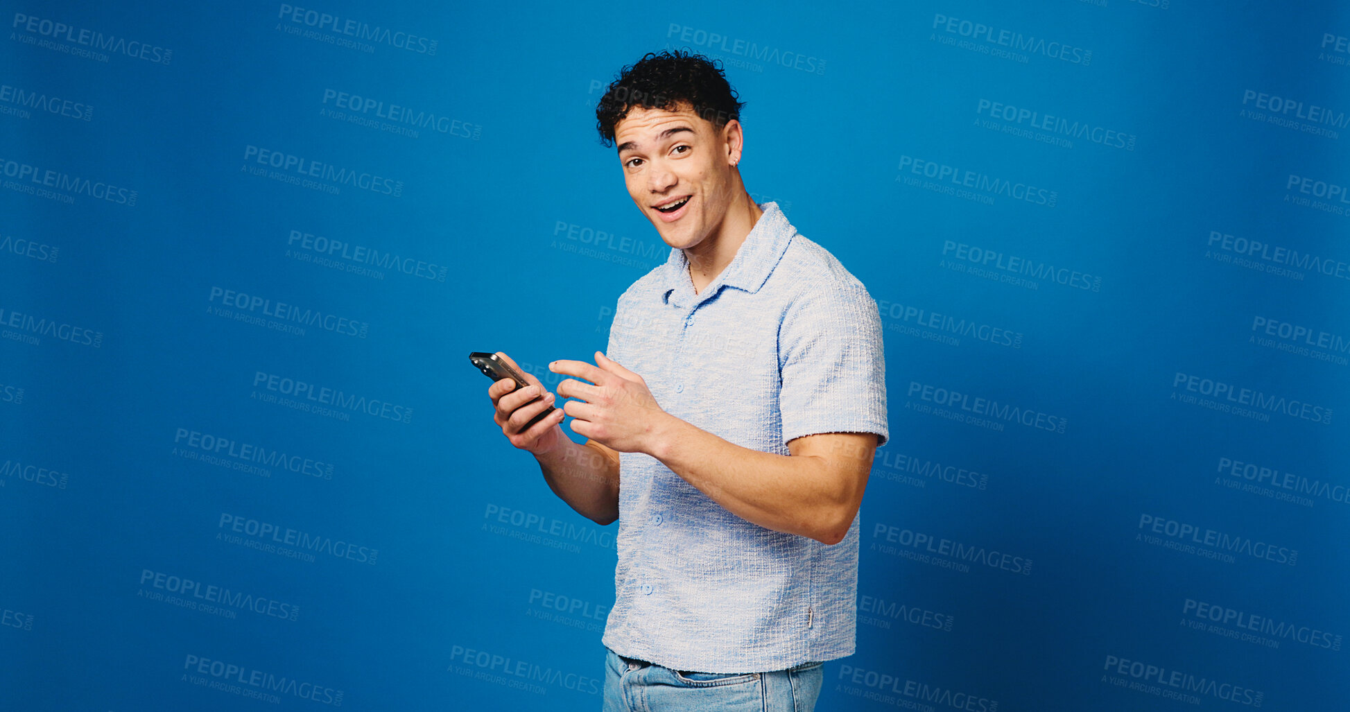Buy stock photo Surprised, phone and portrait with man in studio for lottery results, jackpot winner and prize. Online competition, shocked and mockup space with person on blue background for bonus and giveaway