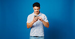 Phone, smile and scroll with man in studio for connection, text message and social media. Online news fee, search and mockup space with person on blue background for post update, typing and network