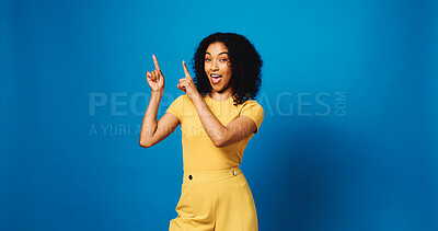 Buy stock photo Portrait, pointing up and woman in studio with promotion, announcement and offer on blue background. Model, space and happy person with hand gesture, smile and opportunity with decision or choice