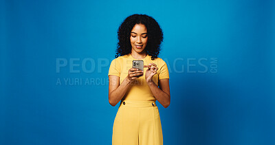 Buy stock photo Browsing, online and woman with smartphone, studio and communication with contact and mock up space. Blue background, happy and person with mobile, texting or message on social media and digital chat