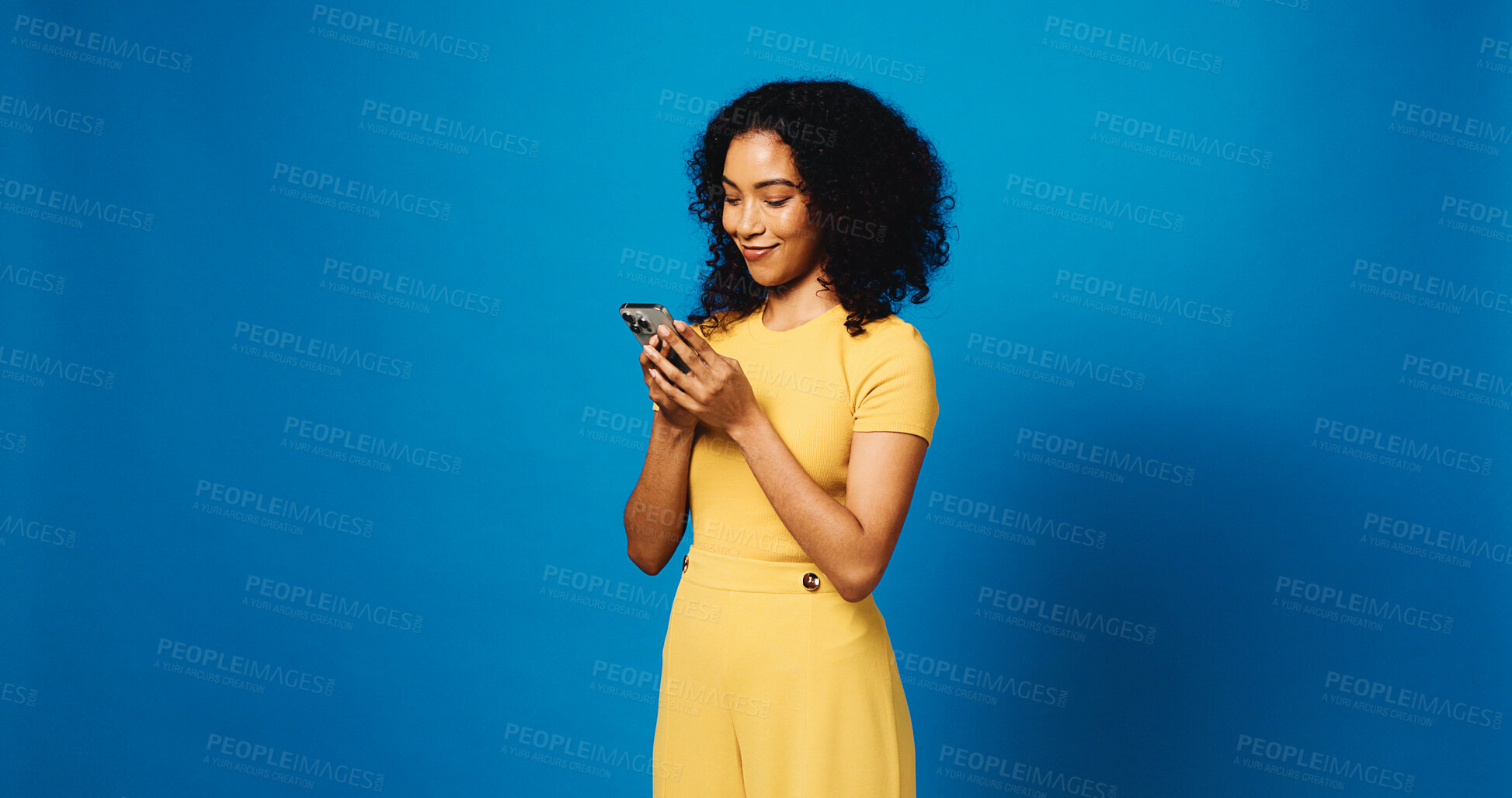 Buy stock photo Phone, happy and woman in studio with networking, communication or texting on mobile app. Mockup space, technology and person with cellphone for chatting, contact or social media by blue background.