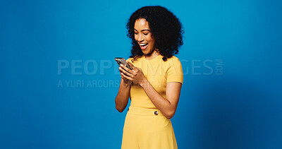 Buy stock photo Happy woman, typing and social media with phone in studio for network service on a blue background. Female person, user or model with mobile smartphone for online chat, texting or app on mockup space