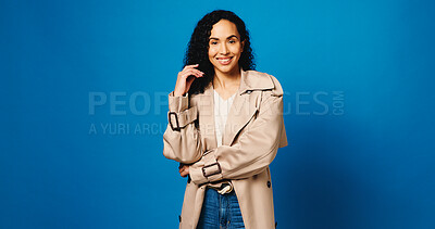 Buy stock photo Fashion, happy and portrait of woman in studio with trendy, trench coat or cool outfit with confidence. Smile, mockup space and female person from Brazil with stylish clothes by blue background.