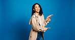 Portrait, pointing and woman in studio with promotion, announcement and offer on blue background. Model, space and happy person with hand gesture, smile and opportunity with decision or choice