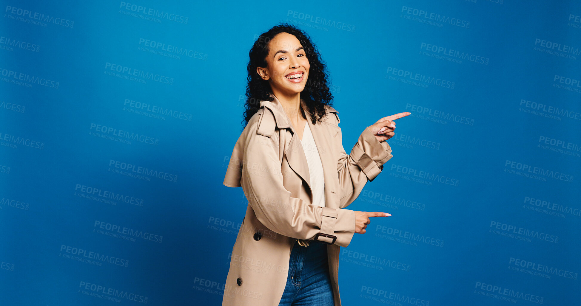 Buy stock photo Portrait, pointing and woman in studio with promotion, announcement and offer on blue background. Model, space and happy person with hand gesture, smile and opportunity with decision or choice