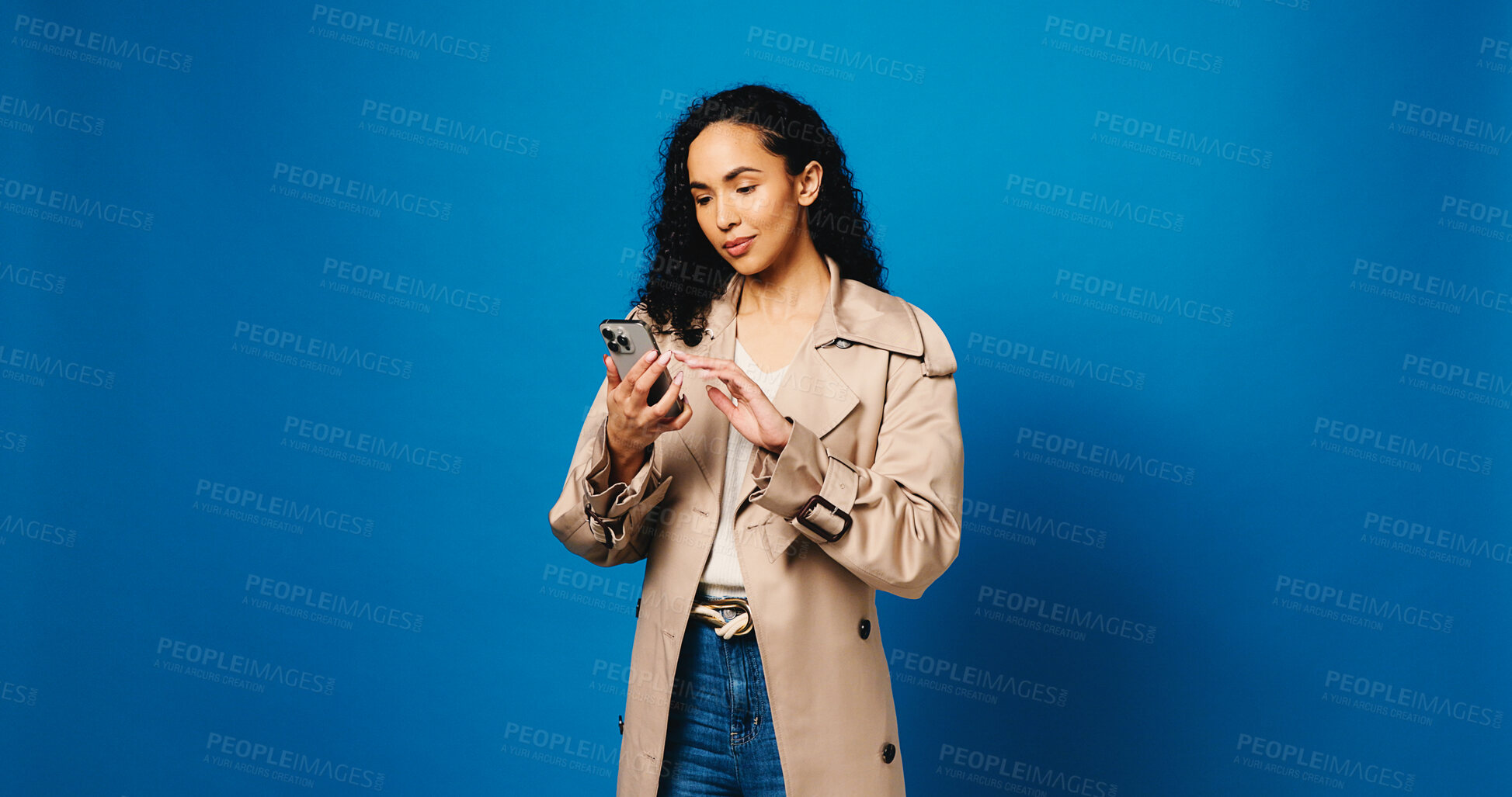 Buy stock photo Phone, reading and typing with woman in studio for connection, text message and social media. Online news feed, search and mockup space with person on blue background for post update and network