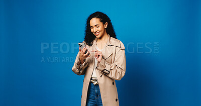 Buy stock photo Phone, app and typing with woman in studio for connection, text message and social media. Online news feed, search and mockup space with person on blue background for post update and network