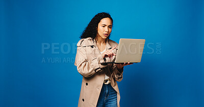 Buy stock photo Laptop, reading and woman fashion designer in studio for market research of trendy style on space. Clothes, computer and small business with design employee isolated on blue background mockup