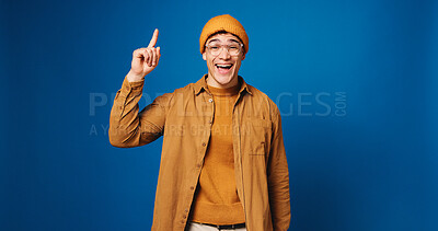 Buy stock photo Happy, man and pointing with portrait in studio for advertising, announcement and coming soon. Mockup space, male person and gesture for sign up, promotion offer and giveaway guide on blue background