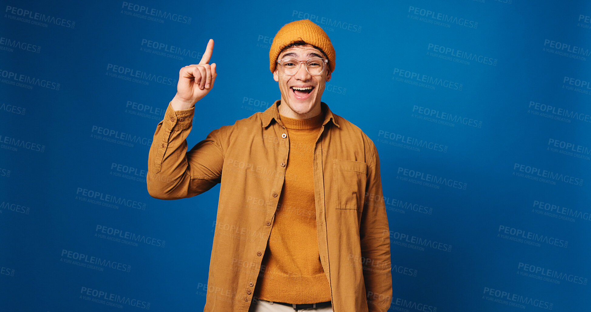 Buy stock photo Happy, man and pointing with portrait in studio for advertising, announcement and coming soon. Mockup space, male person and gesture for sign up, promotion offer and giveaway guide on blue background