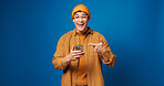 Man, wow or pointing at phone in studio with news, notification or sale on blue background. Surprise, mobile or portrait of excited person with shock for discount, promo or giveaway with mockup space