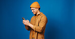 Phone, happy and man in studio with networking, communication or texting on mobile app. Mockup space, technology and person with cellphone for chatting, contact or social media by blue background.