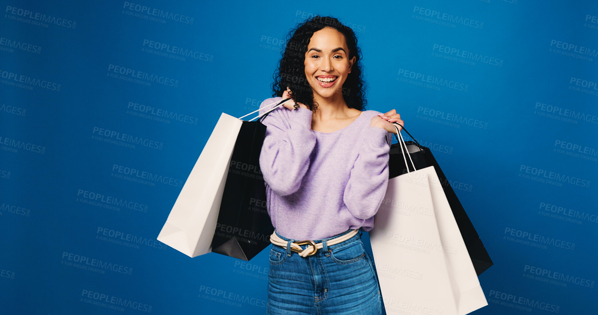 Buy stock photo Happy woman, portrait and studio with shopping bag for discount or fashion on a blue background. Female person, shopper or model with smile or gifts for purchase spree, deal  or choice on space