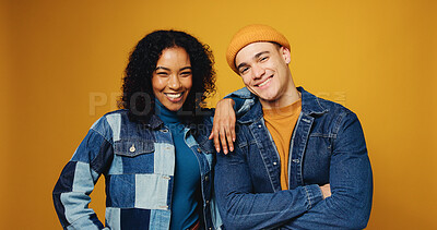 Buy stock photo Portrait, smile and couple in studio for fashion, love and support on yellow background. Happy man, woman and stylish clothes with arms crossed, confidence and care for interracial relationship
