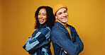 Portrait, arms crossed and happy couple in studio for fashion, love and support on yellow background. Man, woman and stylish clothes with confidence, laugh and care for interracial relationship