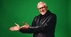 Fashion, pointing and portrait of senior man in studio with mockup space for decision, list or presentation. Happy, glasses and elderly male person with trendy outfit for style by green background.