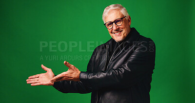 Buy stock photo Fashion, pointing and portrait of senior man in studio with mockup space for decision, list or presentation. Happy, glasses and elderly male person with trendy outfit for style by green background.