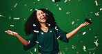 Happy woman, winning and laughing with confetti in studio for party on a green background. Excited, female person or model with smile in celebration for festive surprise, bonus prize or lottery