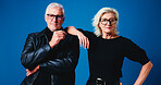 Fashion, studio and portrait of mature couple for trendy eyewear, cool clothes and outfit together. Marriage, space and senior man and woman with attitude, confidence and glasses on blue background
