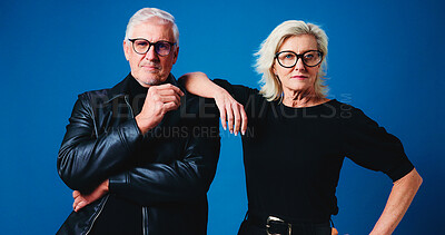Buy stock photo Fashion, studio and portrait of senior couple for trendy eyewear, cool clothes and outfit together. Marriage, stylish and mature man and woman with attitude, confidence and glasses on blue background