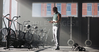 Buy stock photo Smartphone, fitness and black man in gym, internet and digital app to track progress. Mature person, cellphone or health center with equipment, connection or training facility with message to contact