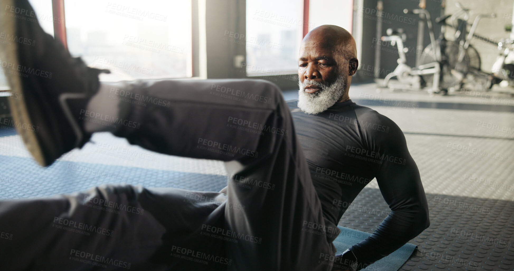 Buy stock photo Legs, exercise and mature black man in gym for core strength, workout and training on floor. Sports center, serious and person on fitness mat for wellness, health and stretching muscles for mobility