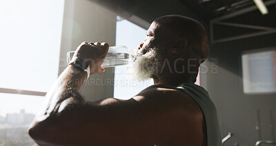 Buy stock photo Fitness, exercise and man with drinking water at gym for hydration, workout recovery and resting. Athlete, window or mature person with liquid at sports club for training break, thirsty and nutrition