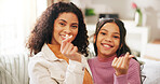 Finger heart, portrait and woman with daughter on sofa in living room of home for gratitude or love. Emoji, hand gesture and smile of girl child with mother in apartment together for family bonding