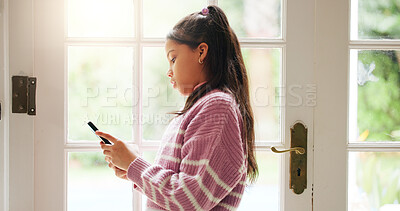 Buy stock photo Girl, child and typing with phone in home for social media browsing, online game and web addiction. Kid, smartphone and texting by door with streaming subscription, internet dependence and scrolling