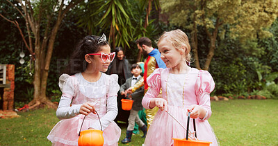 Buy stock photo Candy, halloween and walking with girls outdoor together for celebration, fantasy or holiday. Bonding, bucket and conversation with children friends in neighborhood for trick or treat tradition
