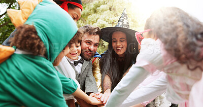 Buy stock photo Halloween, hands together and happy with family outdoor for costume, celebration and trick or treat. Huddle, support and spooky tradition with group of kids and parents in backyard for holiday