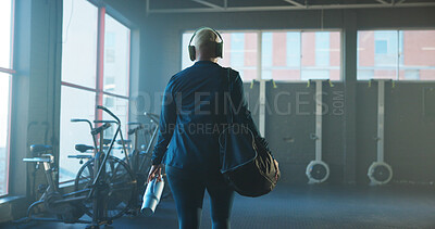 Woman, back and walking with gym bag for workout preparation or getting ready to start exercise. Female person, water bottle and headphones with gear for fitness or begin training in health club