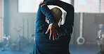 Woman, back view and stretching with arm in gym for workout preparation, fitness or flexibility. Active, female person or getting ready with warm up for physical exercise or training in health club