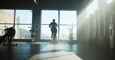 Buy stock photo Fitness, back of woman and stationary bike at gym for cardio training, cycling routine or wellness. Sunlight, athlete and elliptical machine at sports club for endurance challenge or burning calories
