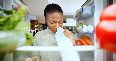 Buy stock photo Black woman, fridge or smell with expired milk at house for bad odor, foul scent or spoiled product. Pov, female person or check for rotten ingredients, food safety or forgotten diary in refrigerator