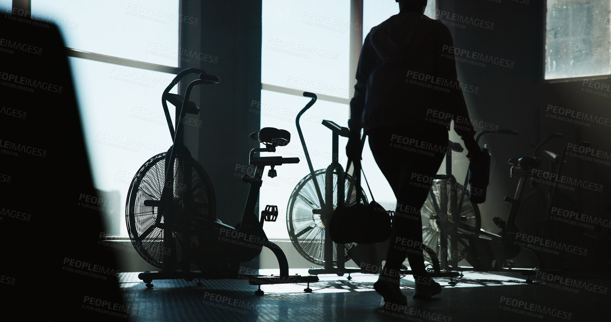 Buy stock photo Exercise bike, walking and woman in gym for start of cardio training, fitness or workout routine. Back, machine and stationary bicycle with person in health club for cycling or spinning class