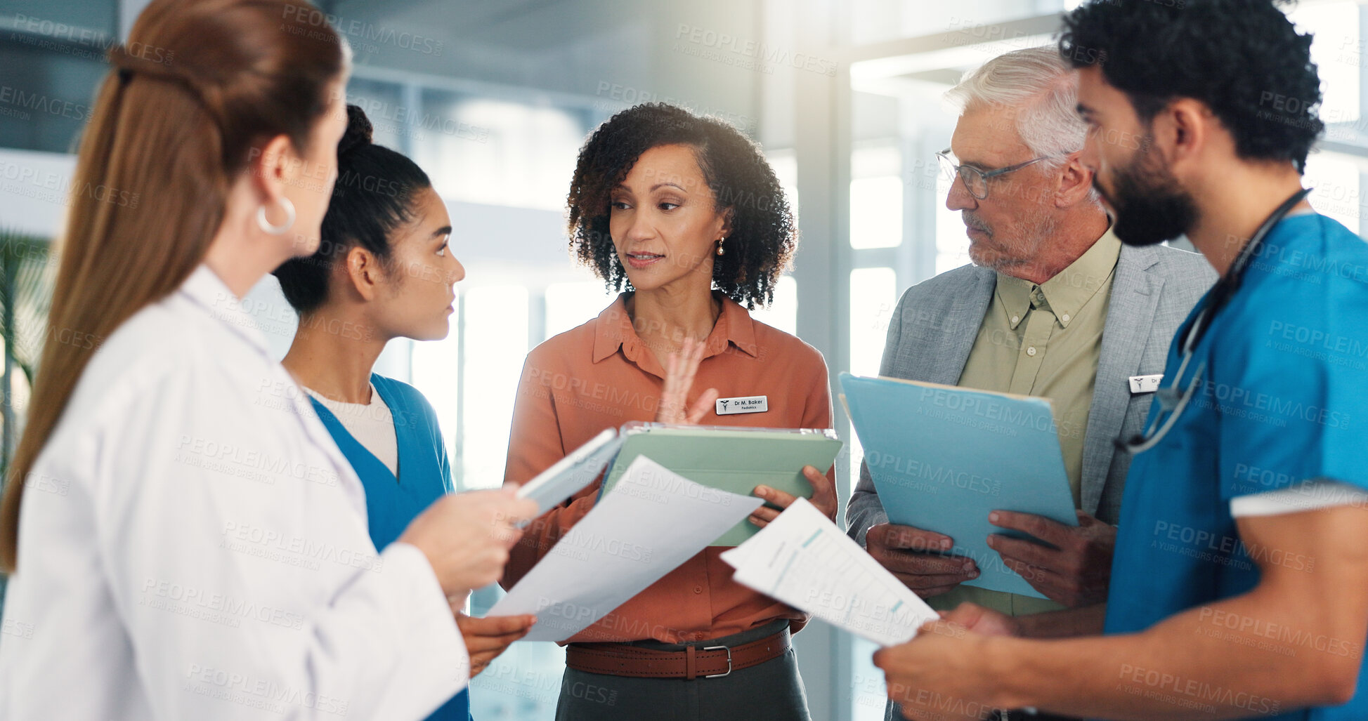 Buy stock photo Woman, doctors and team with tablet, planning and review for healthcare services at hospital. Leader, group and talk with tech, documents and app for report, advice or discussion at medical clinic