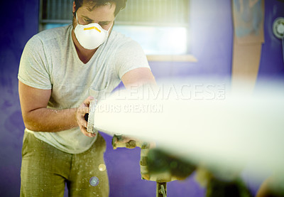 Buy stock photo Man, face mask and sanding surfboard in workshop to smooth surface, shaping process and repair work. Person, safety and tools for diy restoration, board maintenance and polish craft to prepare finish