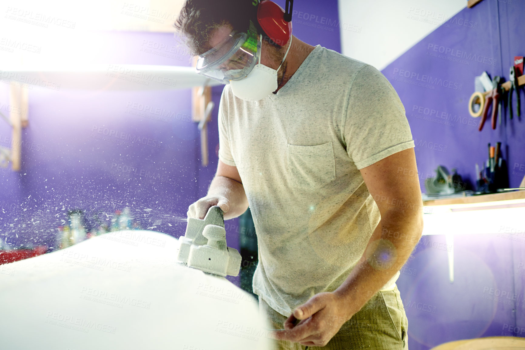 Buy stock photo Man, tools and sanding surfboard in workshop to smooth surface, shaping process and repair work. Person, face mask or machine for diy restoration, board maintenance and polish craft to prepare finish